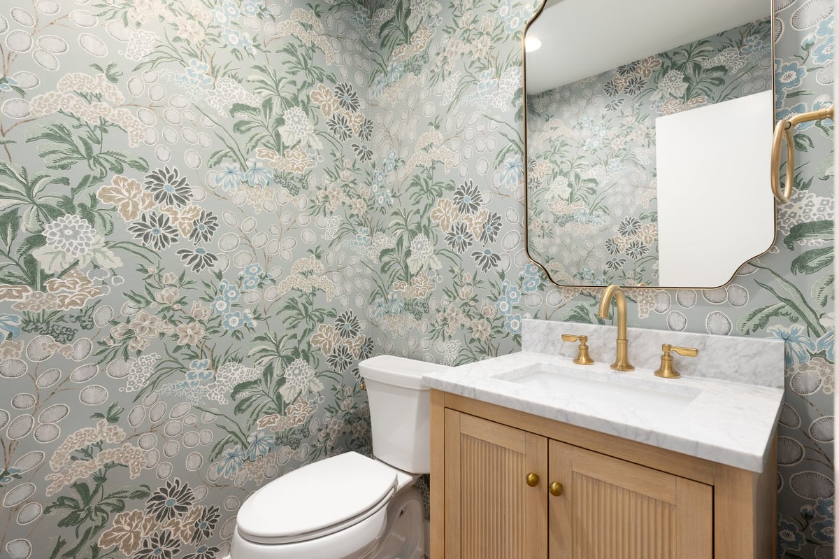 Half bathroom with marble countertop and gold fixtures